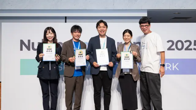 「認定バックログスイーパー」2025 就任式で、認定バックログスイーパーの方々が認定証を持って記念撮影をしている。株式会社ヌーラボ代表取締役の橋本正徳も同席している。